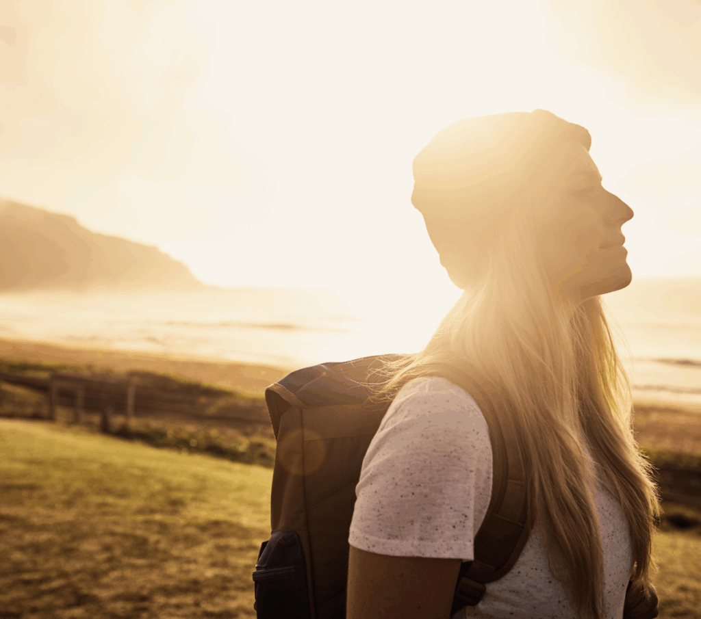Femme heureuse en voyage, incarnant liberté, découverte de soi et renouveau après le cancer, symbole d’épanouissement personnel soutenu par le coaching féminin bienveillant