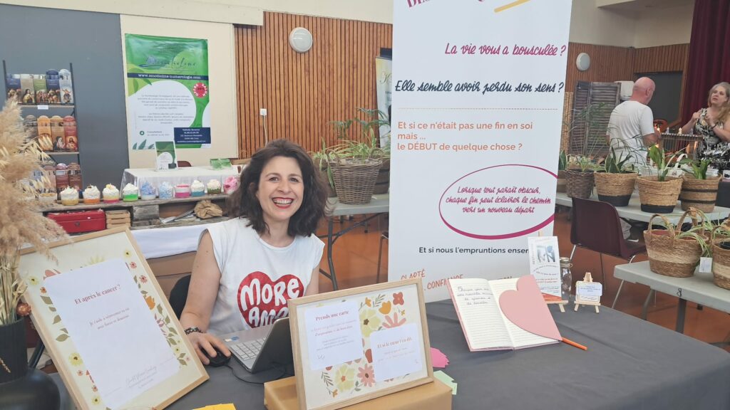 Chantal Marin présente sur un stand, illustrant son rôle de coach spécialisée dans l’accompagnement des femmes touchées par le cancer, offrant écoute, soutien et conseils personnalisés lors d’événements ou salons